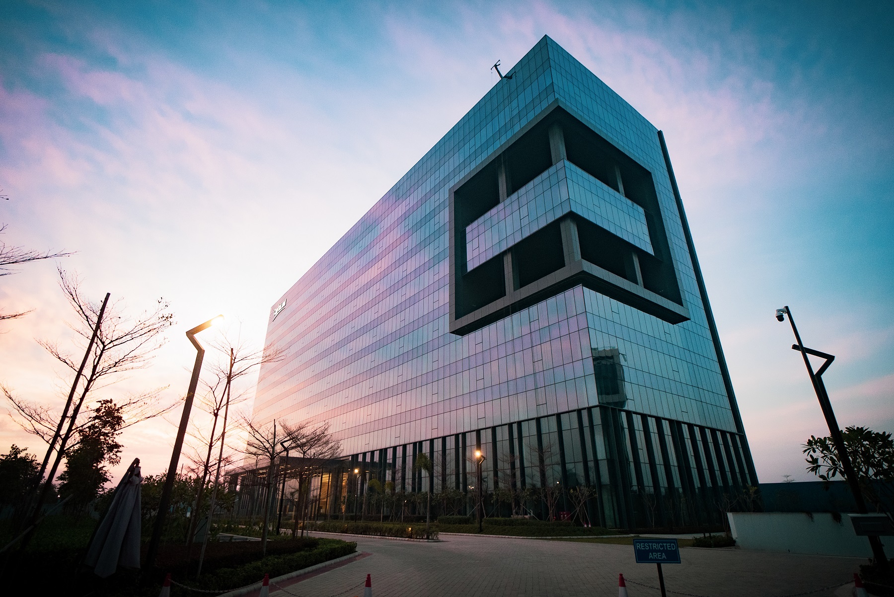 A modern glazed building looks stunning as the sunrise rises behind its profile