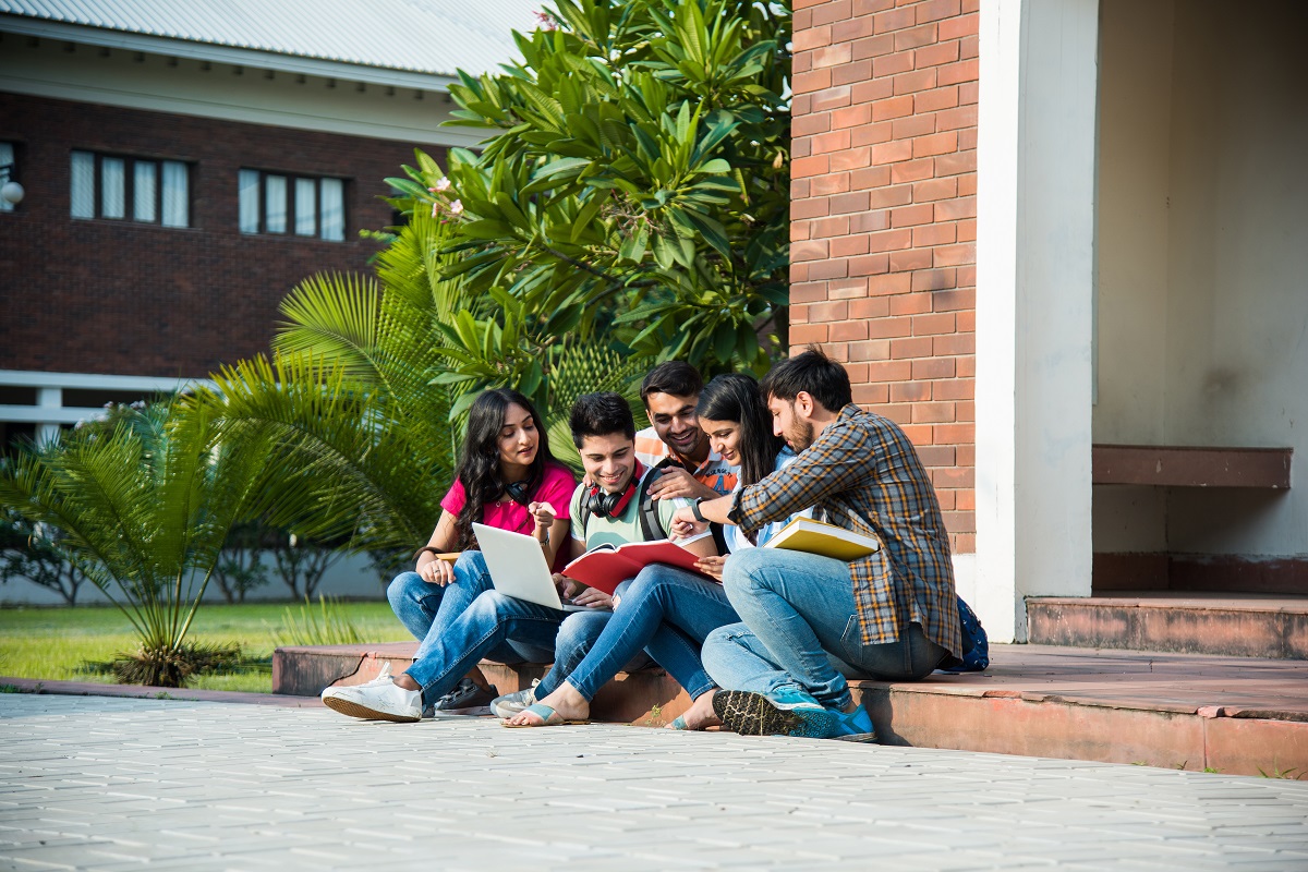 A group of students sat outside comparing notes
